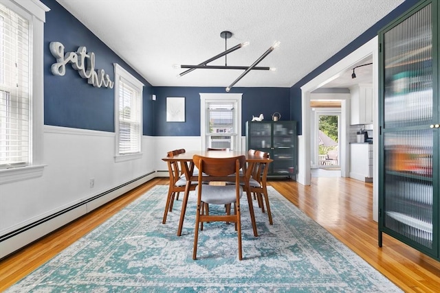 10 Saunders Rd, Lynn, MA 01904 - dining room with a baseboard radiator, a textured ceiling, wood finished floors, wainscoting, and a chandelier