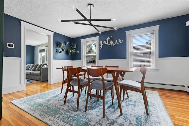 10 Saunders Rd, Lynn, MA 01904 - dining space with a textured ceiling, wainscoting, plenty of natural light, wood finished floors, and baseboard heating