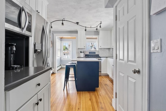 10 Saunders Rd, Lynn, MA 01904 - kitchen with appliances with stainless steel finishes, light wood-style floors, decorative backsplash, and white cabinets