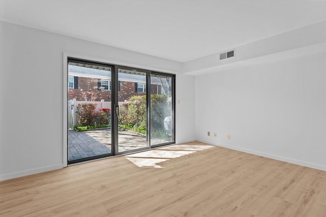 empty room featuring light wood finished floors and baseboards