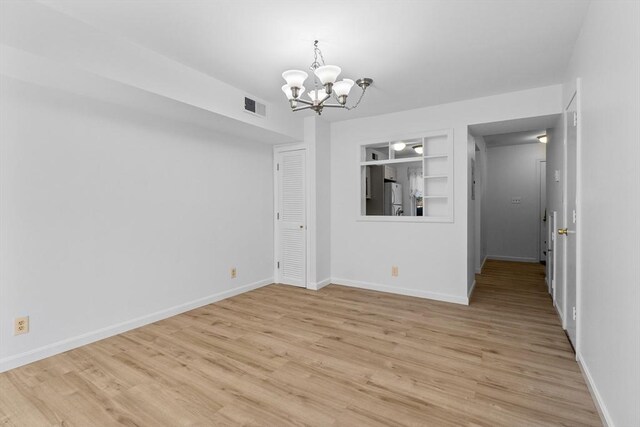 unfurnished dining area featuring a chandelier, built in features, light wood finished floors, and baseboards