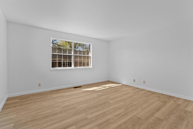 unfurnished room with light wood-style floors and baseboards