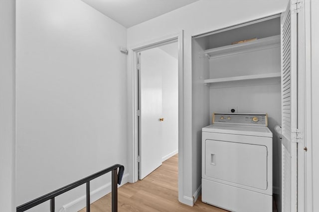 washroom featuring washer / clothes dryer, light wood-type flooring, and baseboards