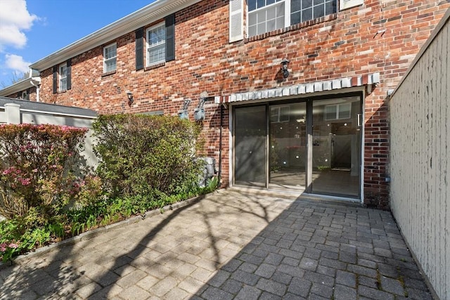 back of property featuring brick siding and a patio