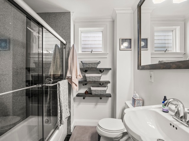 full bathroom featuring sink, ornamental molding, bath / shower combo with glass door, and toilet