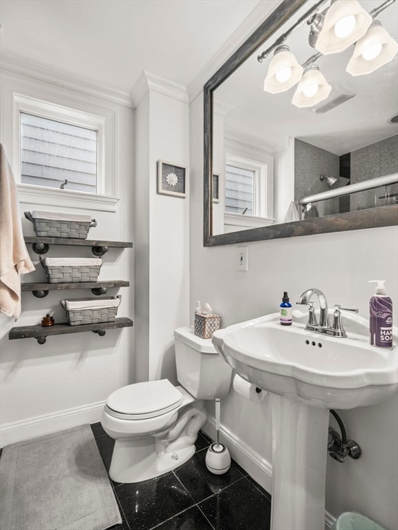 bathroom with tile patterned flooring, ornamental molding, a healthy amount of sunlight, and toilet