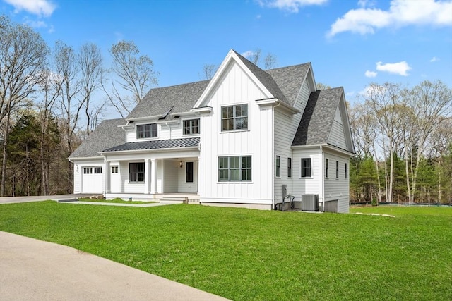 view of front of home with covered porch, a front yard, board and batten siding, an attached garage, and driveway