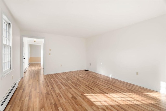 unfurnished room with light hardwood / wood-style flooring and baseboard heating