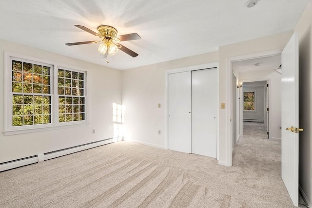 unfurnished bedroom with ceiling fan, a closet, light colored carpet, and a baseboard heating unit