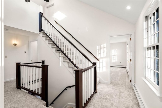 staircase with carpet, baseboard heating, and high vaulted ceiling