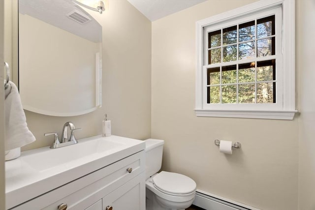 bathroom with vanity, toilet, and a baseboard heating unit