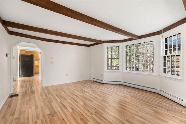 spare room featuring beamed ceiling and light hardwood / wood-style flooring