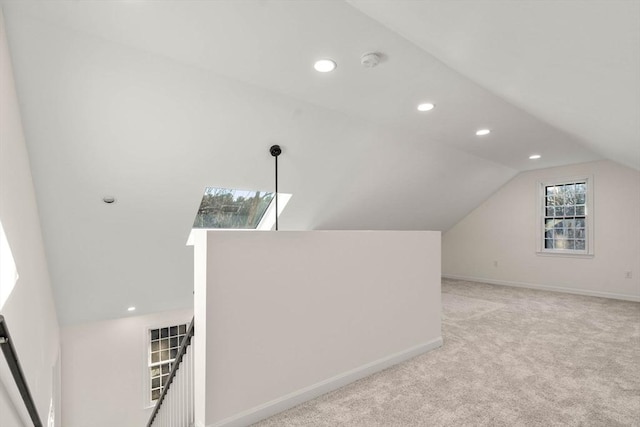 additional living space with light carpet and vaulted ceiling