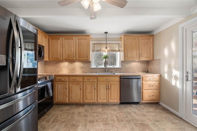 kitchen featuring ceiling fan, sink, stainless steel appliances, tasteful backsplash, and decorative light fixtures