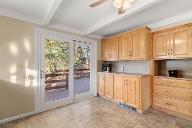 kitchen with tasteful backsplash, ceiling fan, light brown cabinets, and beam ceiling