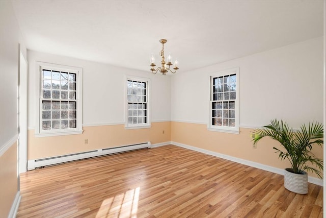 empty room with light hardwood / wood-style floors, an inviting chandelier, and a baseboard heating unit