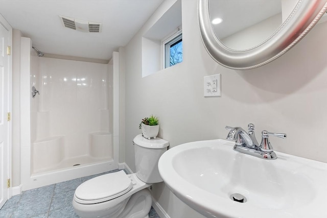 bathroom featuring toilet, baseboards, a sink, and a shower