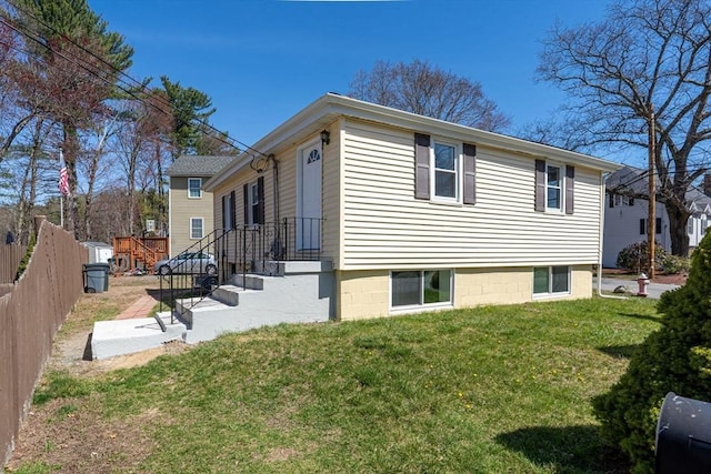 view of property exterior with a lawn and fence