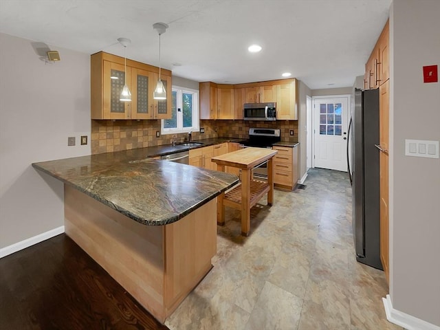 kitchen featuring a peninsula, baseboards, stainless steel appliances, and decorative backsplash