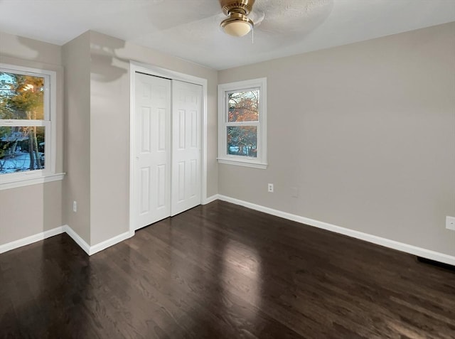 unfurnished bedroom with a ceiling fan, a closet, baseboards, and wood finished floors