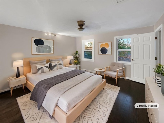 bedroom featuring dark wood finished floors and baseboards