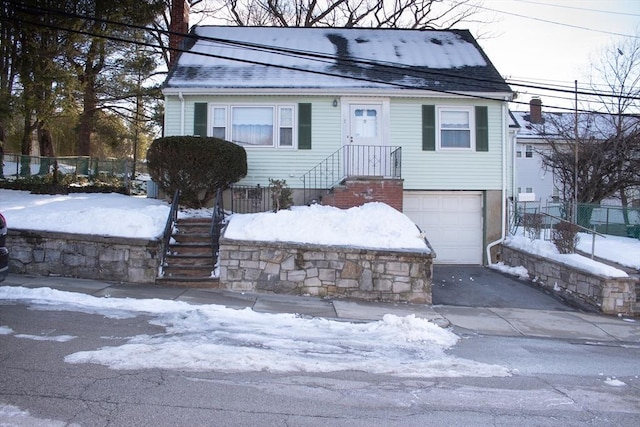 view of front of property with a garage, driveway, a chimney, and fence