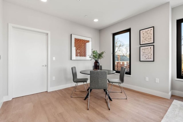 dining space featuring light wood finished floors, baseboards, and recessed lighting