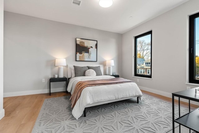 bedroom with light wood finished floors and baseboards