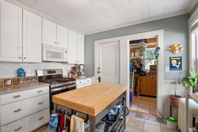 69 Bradfield Ave Unit 1, Boston, MA 02131 - kitchen featuring white microwave, stainless steel range with gas stovetop, light countertops, white cabinetry, and ornamental molding