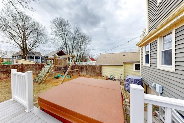 deck with grilling area, fence private yard, and a playground