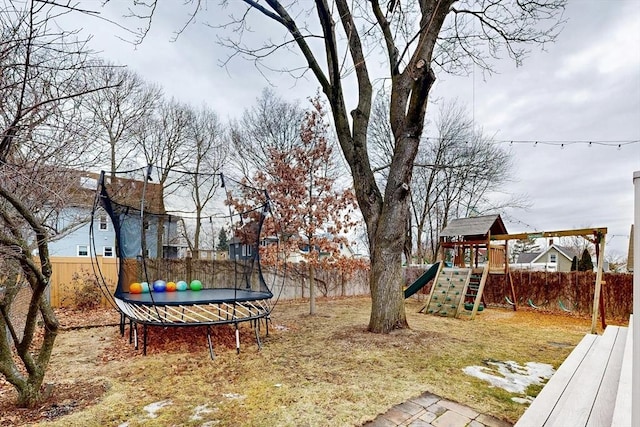 view of yard featuring a fenced backyard, a playground, and a trampoline