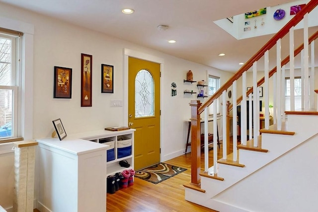 foyer entrance with recessed lighting, stairway, baseboards, and wood finished floors