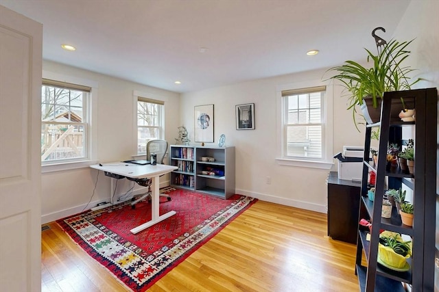 office space with baseboards, plenty of natural light, and wood finished floors