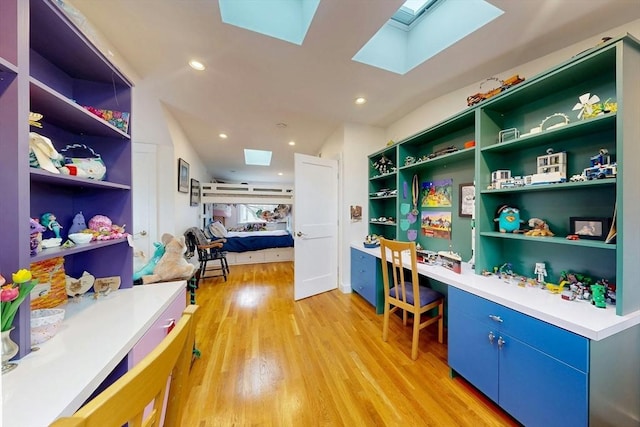 interior space with built in desk, recessed lighting, a skylight, and light wood-style floors