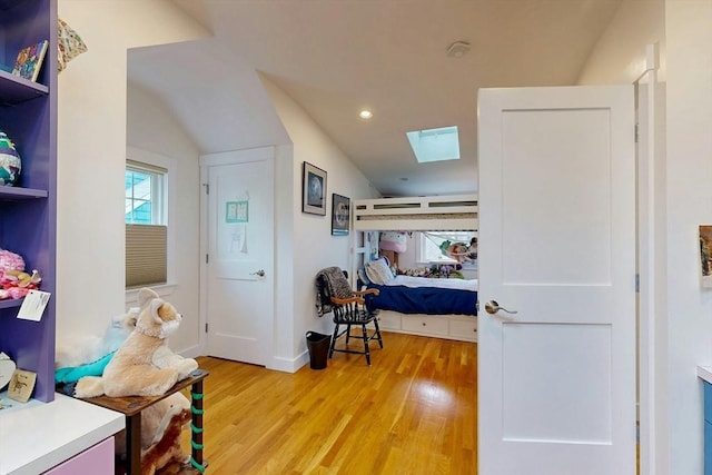 interior space featuring a skylight, recessed lighting, baseboards, and light wood finished floors