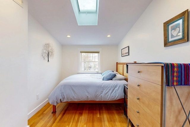 bedroom with recessed lighting, baseboards, wood finished floors, and a skylight