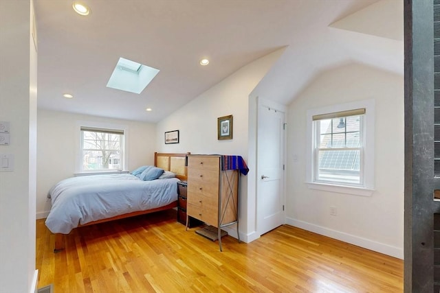 bedroom with recessed lighting, vaulted ceiling with skylight, baseboards, and light wood-style floors