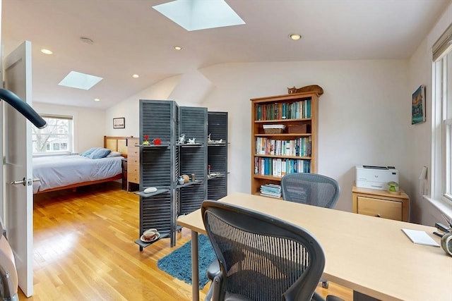 office area featuring vaulted ceiling with skylight, light wood-style flooring, and recessed lighting