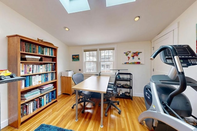 office featuring vaulted ceiling with skylight, recessed lighting, light wood-type flooring, and baseboards