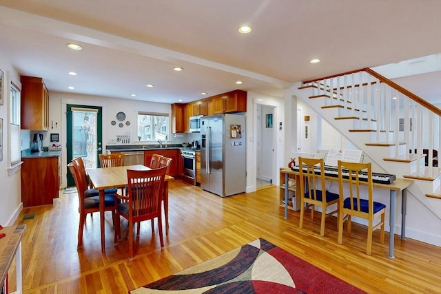 dining area featuring recessed lighting, baseboards, light wood-style flooring, and stairs