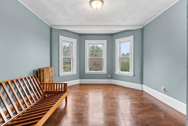 unfurnished room with wood-type flooring and baseboards