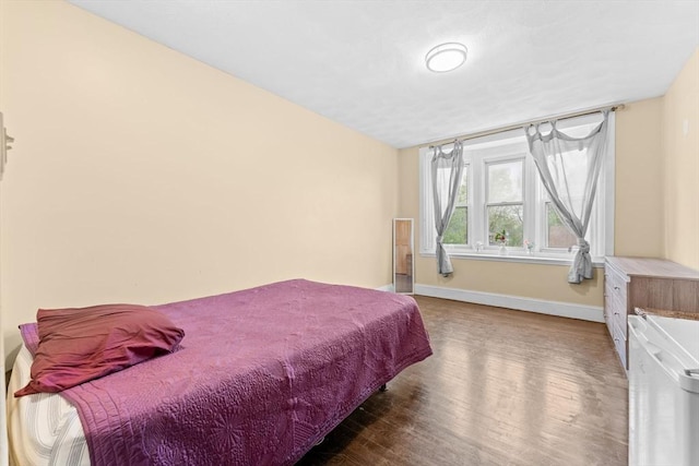 bedroom with baseboards and wood finished floors