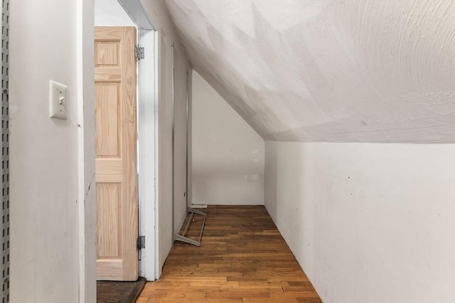 hallway featuring lofted ceiling and wood finished floors