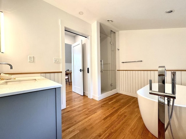 84 Walden Ter, Concord, MA 01742 - full bathroom featuring a shower stall, wood finished floors, a wainscoted wall, a freestanding bath, and vanity