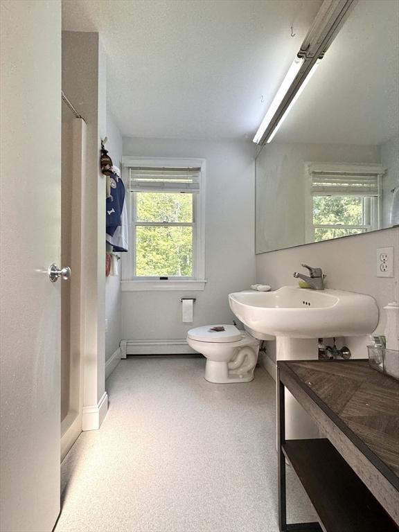 84 Walden Ter, Concord, MA 01742 - bathroom featuring plenty of natural light, toilet, a baseboard heating unit, and baseboards