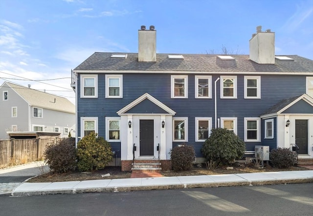 view of front of property with a chimney and fence