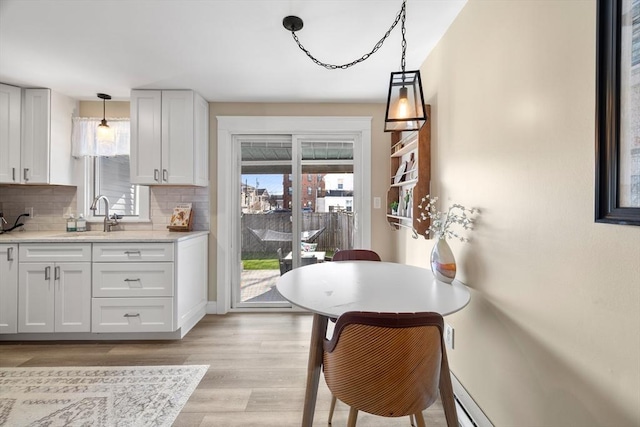 dining area featuring baseboards and light wood-style floors