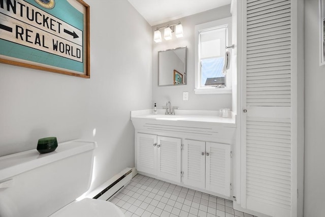 bathroom with a baseboard heating unit, toilet, vanity, and tile patterned flooring