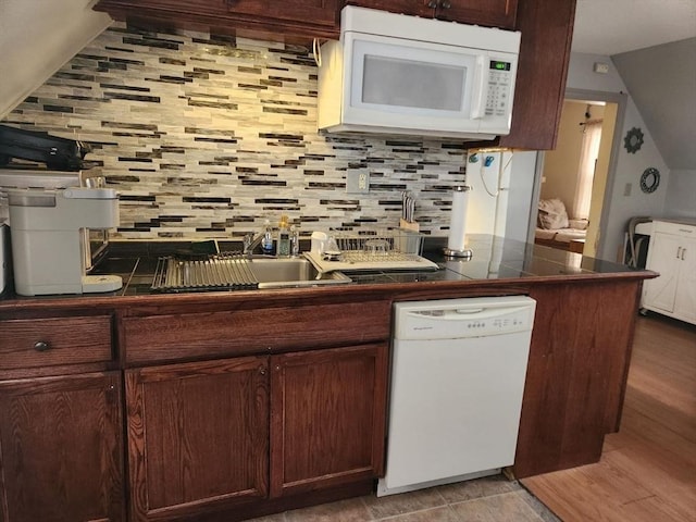 kitchen featuring white appliances, tasteful backsplash, dark brown cabinetry, and light wood-type flooring