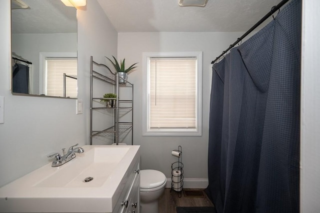 bathroom featuring vanity, hardwood / wood-style floors, walk in shower, and toilet